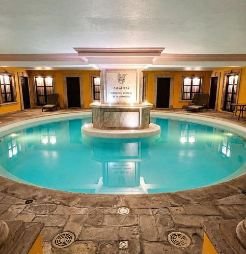 a large swimming pool with a fountain in a building at Meson de la Merced in Zacatecas