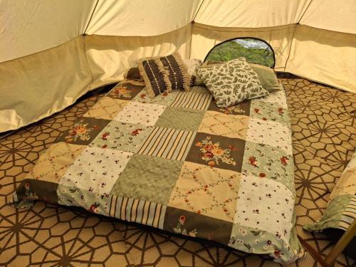 a bed in a tent with pillows on it at Sleep4GlampingTent-NearTralee-Countryside in Tralee