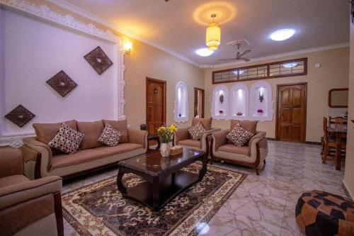 a living room with couches and a coffee table at Sunny Palms Beach Bungalows in Uroa