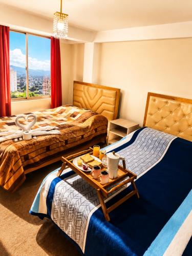a hotel room with two beds and a table with food on it at Hotel Golden La Paz in Callampaya