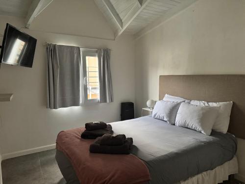 a bedroom with a bed with towels on it at Sur Alojamiento Ushuaia in Ushuaia