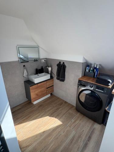 a bathroom with a washing machine and a sink at Nordwind in Langenhorn