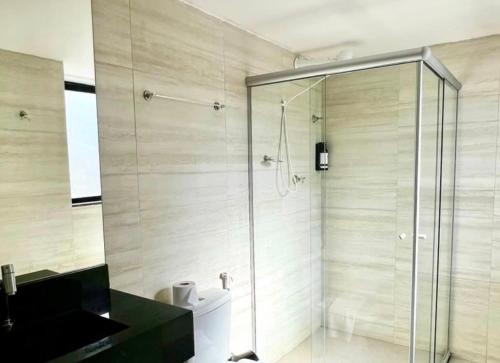 a bathroom with a shower with a glass door at Amazon Seasons Suíte Premium em Belém in Belém