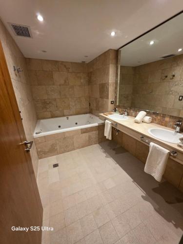a bathroom with a tub and a sink and a bath tub at Azahar Hotel & Spa in San Pedro