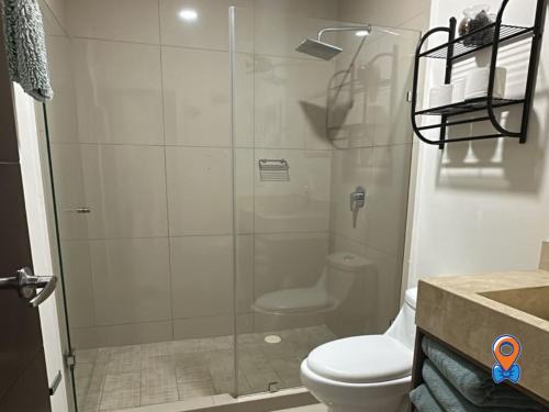 a bathroom with a glass shower with a toilet at Depa Amplio Vista al Mar Cerca del Malecón in Mazatlán