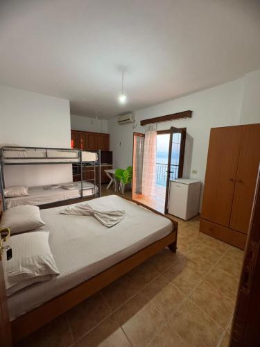 a bedroom with a large bed and a kitchen at Villa Denis Gjeta in Borsh