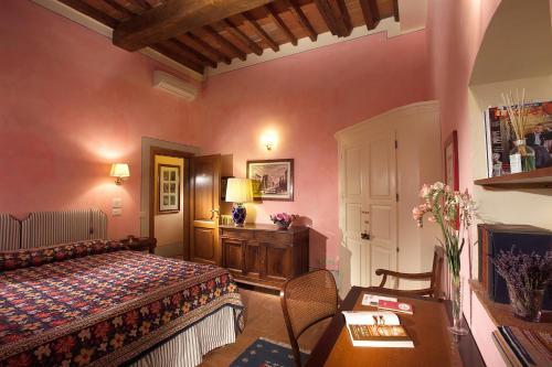 a bedroom with a bed and a desk and a table at Antica Dimora Firenze in Florence