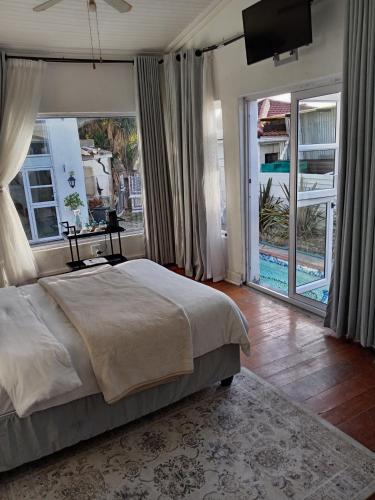 a bedroom with a large bed and a large window at M Group B&B in King Williamʼs Town