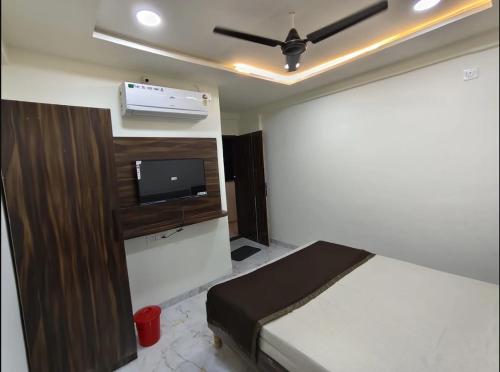 a bedroom with a bed and a flat screen tv at ishwari heights lodging in Pandharpur