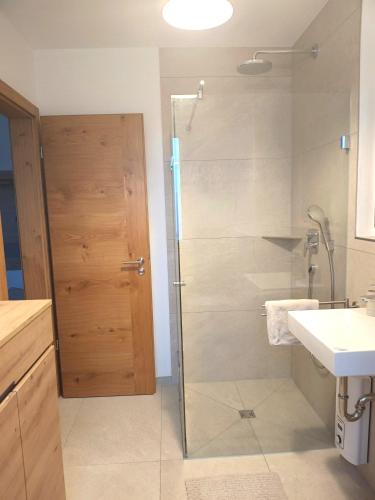 a bathroom with a shower with a glass door at Exclusive Apartment mit Alpenpanorama in Peiting