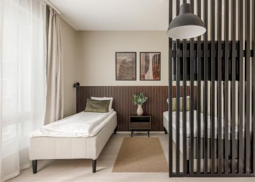 a small bedroom with a bed and a chair at Calm Design Studio with Balcony & Parking in Pori
