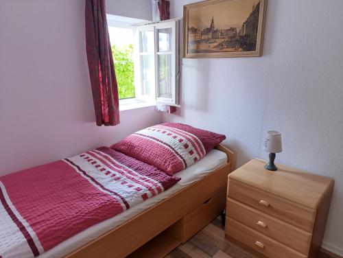 a small bedroom with a bed and a window at Ferienhof Saalendorf in Großschönau