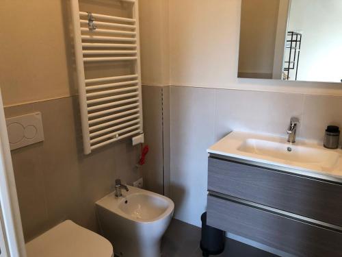 a bathroom with a sink and a toilet and a mirror at La Casina di Titty in Stia