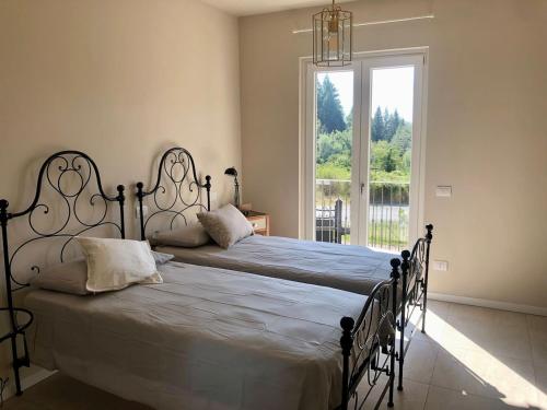 a bedroom with a large bed and a large window at La Casina di Titty in Stia
