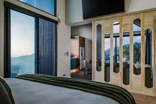 a bedroom with a large bed with a large window at Lakay Monteverde with Heated Pool, Golf Cart and Breakfast in Monteverde Costa Rica