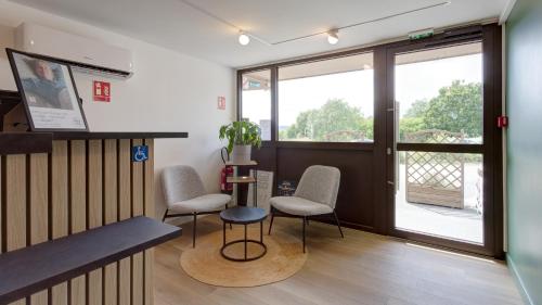 a waiting room with two chairs and a table at Campanile Epernay - Dizy 51530 in Épernay