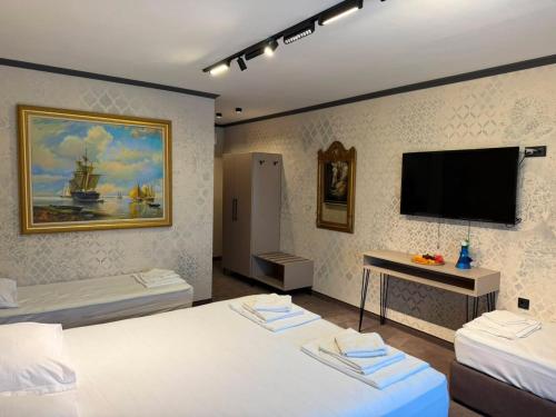 a room with two beds and a flat screen tv at Комплекс Шампион in Kazanlŭk