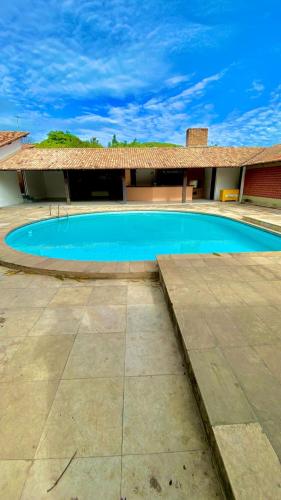a large swimming pool in front of a house at Pousada Cajueiro Beach House in Parnaíba