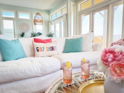 a living room with a white couch with colorful pillows at Oceanfront/Zero Steps to Beach/Views/4BR in Gulf Shores