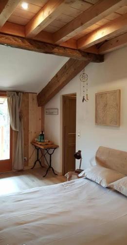 a bedroom with a bed and a table in a room at Chambres d'hôtes St Jacques Adults only in Saint-Lizier