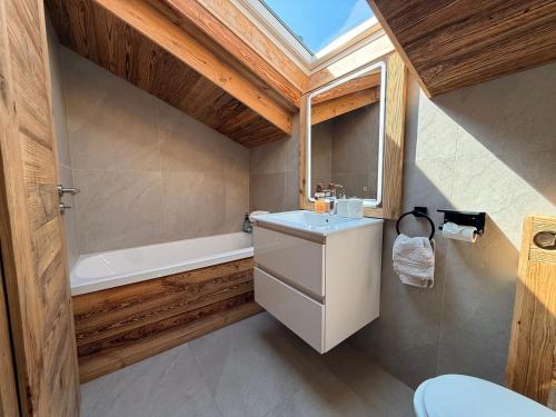 a bathroom with a sink and a bath tub at Attique de la Moubra 4 in Crans-Montana