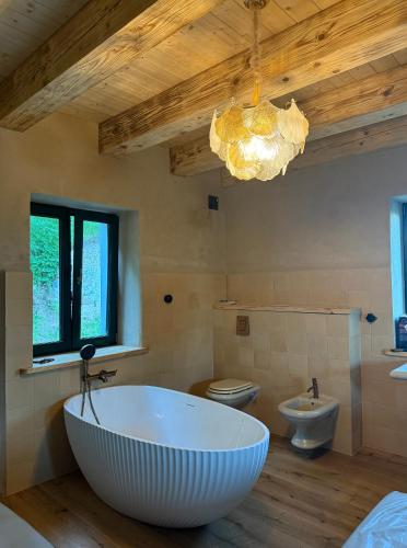 a large bathroom with a large tub and two toilets at Zawiszyn 12 in Dubeninki
