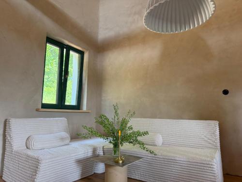 a living room with two white chairs and a table at Zawiszyn 12 in Dubeninki