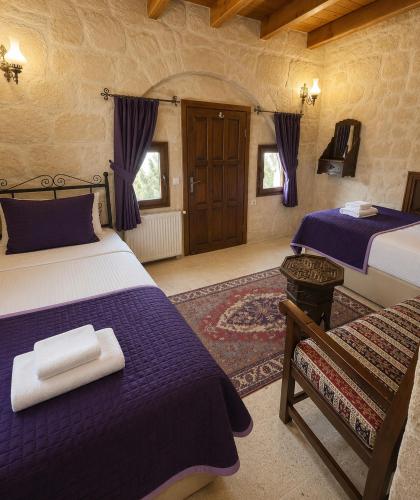 a bedroom with two beds with purple sheets at Turquaz Cave Hotel in Göreme