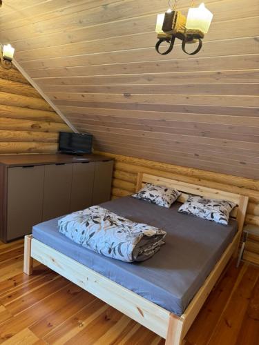 a bed in a room with a wooden wall at Релакс in Svityazʼ