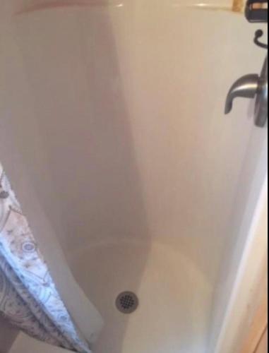 a white bath tub with a shower curtain and a sink at Casa Rosa Unit C on Lake Conroe in Willis