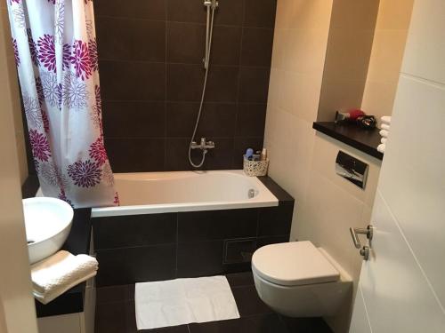 ein Badezimmer mit einer Badewanne, einem WC und einem Waschbecken in der Unterkunft Apartment Gorki in Belgrad
