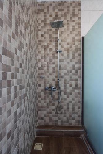 a bathroom with a shower in a tiled wall at Villa Dahl Beach Resort in Dar es Salaam