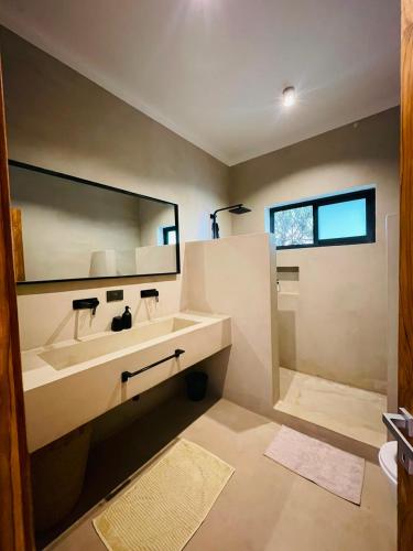 a bathroom with a sink and a large mirror at Solymar Villa 3 in Jambiani