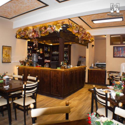 a restaurant with a bar with tables and chairs at Hotel y Restaurante Manhattan in La Tenería