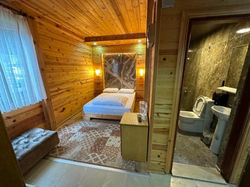 a bedroom with a bed in a wooden cabin at Ayder Serender Otel in Çamlıhemşin