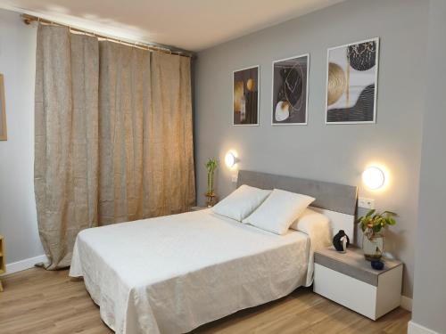 a bedroom with a white bed and a window at A un paso de Laurel Estudio con balcón in Logroño