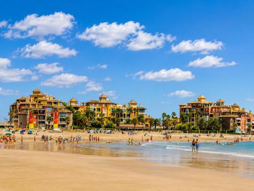 a group of people on the beach at a resort at Alcaraván, Isla Canela - By AC REAL in Isla Canela