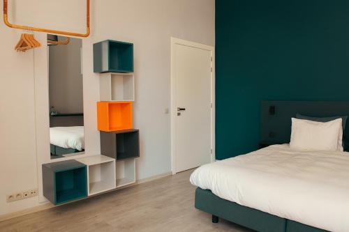 a bedroom with a bed and a blue wall at B&B Inn Between in Ghent