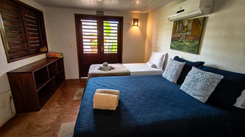 a bedroom with a large bed with a blue blanket at Icarai Kite House in Icaraí