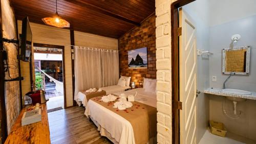 a bedroom with a bed and a couch in a room at Pousada Mar Aberto in Fernando de Noronha