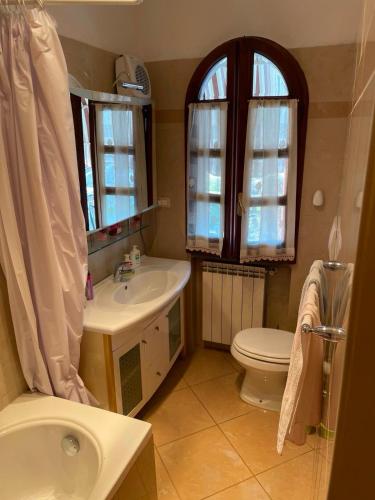 a bathroom with a sink and a toilet and a window at Sweet home Torre del lago in Torre del Lago Puccini