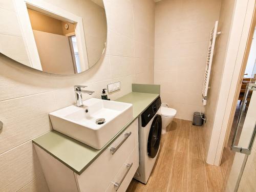 a bathroom with a sink and a washing machine at Can Costals Cerezo in Pals