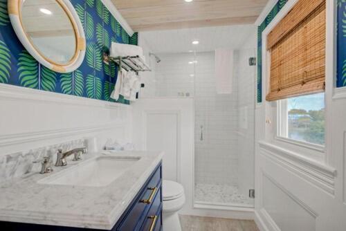 a bathroom with a sink and a toilet and a mirror at The Hewitt Wellington Hotel in Spring Lake