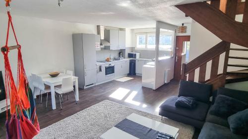 a living room with a couch and a table and a kitchen at Duplex à 2 pas de l'aéroport, proche ONU & Palexpo in Ferney-Voltaire