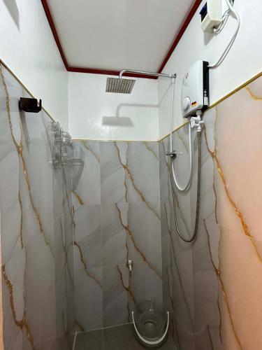 a bathroom with a shower with a glass door at Tiny house studio near SM City Daet in Daet