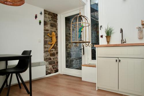 a kitchen with white cabinets and a table and a window at Escapade tropicale au Costa Rica in Profondeville