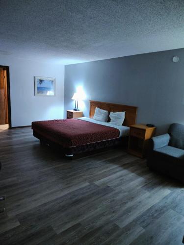 a bedroom with a bed and a couch and a chair at Heritage Inn in Fairview