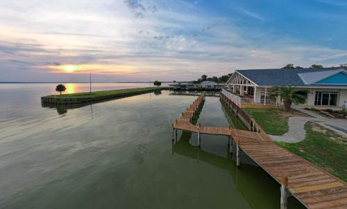 a house on the water with a dock at Settle Into a Cozy Lakeside Glamping Escape in Onalaska