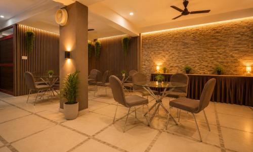 a restaurant with a table and chairs and a brick wall at Hotel Rise Grand Kukatpally Near Hitex Exhibition Center & Nexus Mall, Yashoda Hospital in Hyderabad