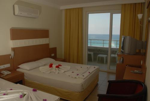 ein Hotelzimmer mit zwei Betten und Balkon in der Unterkunft Sunstar Beach Hotel in Mahmutlar